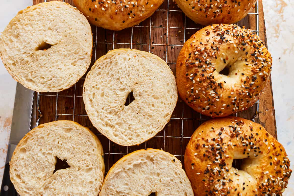 sliced homemade bagels on a wire rack.