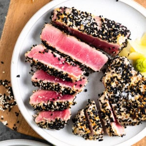 overhead view of a plate of ahi tuna steaks, coated in sesame seeds and sliced thinly.