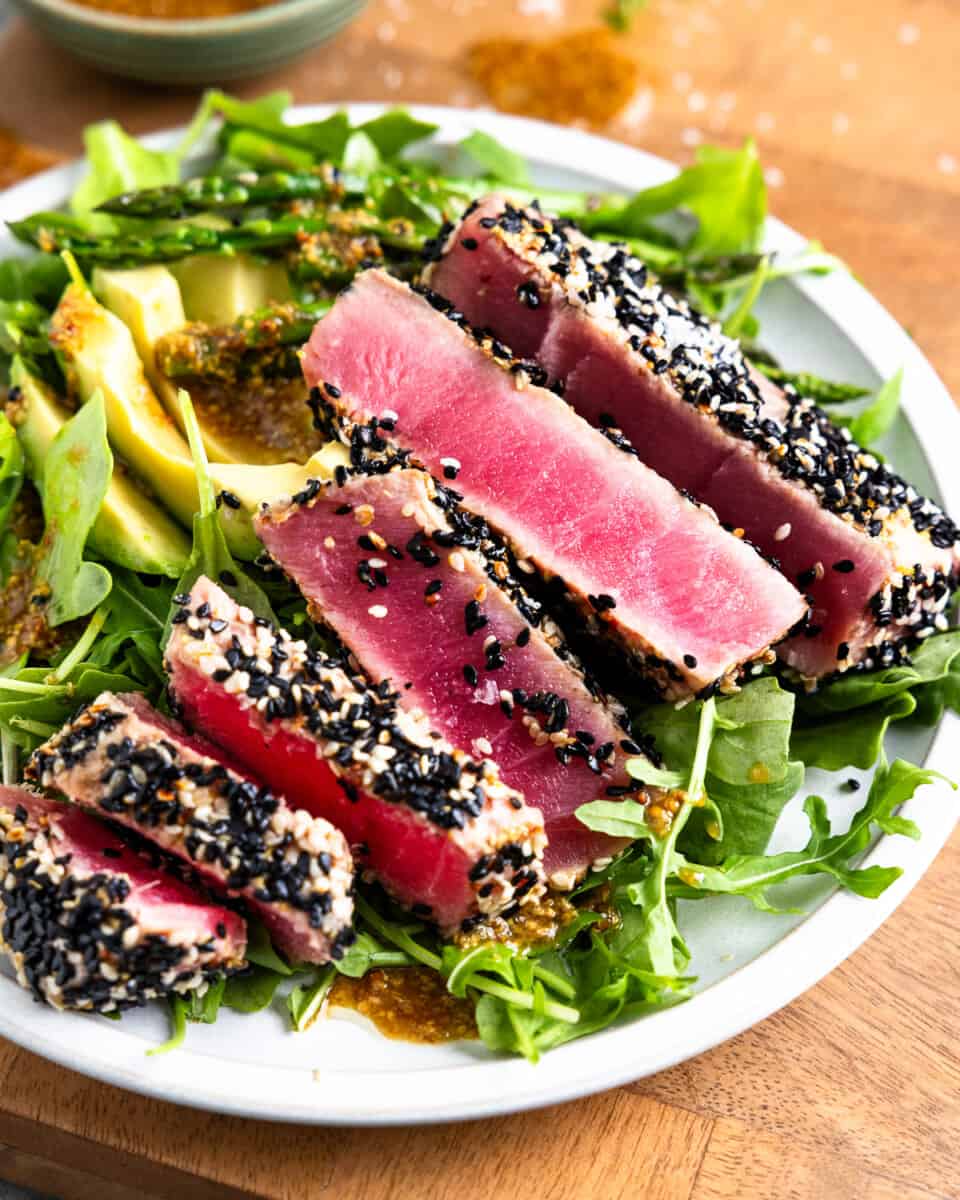 slices of seared ahi tuna on a plate of salad.
