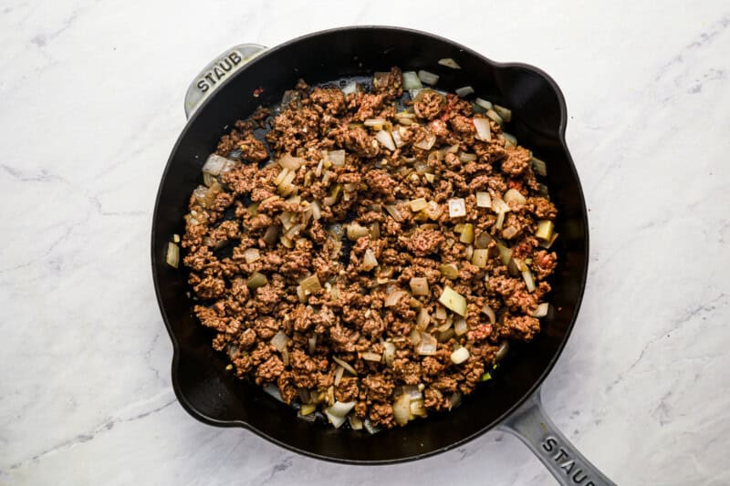 cooked seasoned ground beef and onions in a pan.