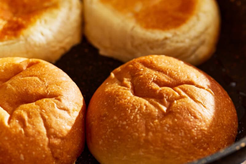 toasting hamburger buns in a pan.