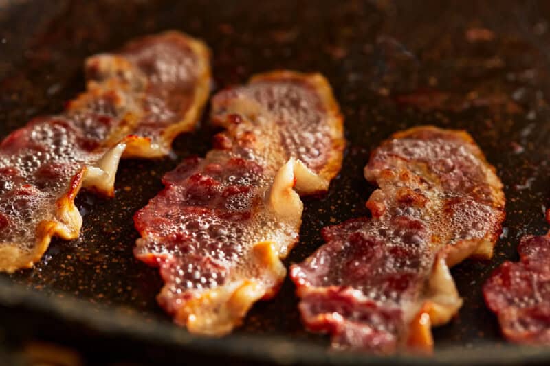 cooking bacon in a pan.