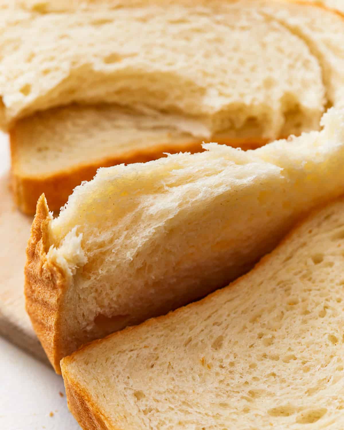 close up of a torn slice of white sandwich bread.