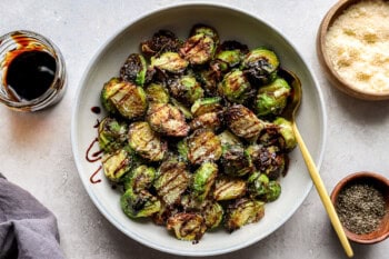 A bowl filled with crispy Brussels sprouts drizzled with balsamic.