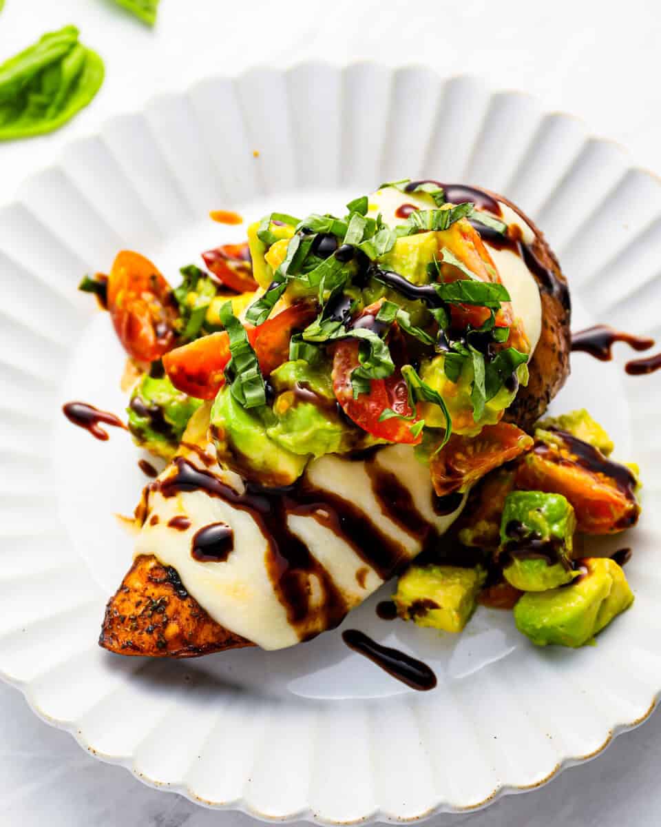 Grilled California chicken breast with avocado tomato salsa on a white plate.
