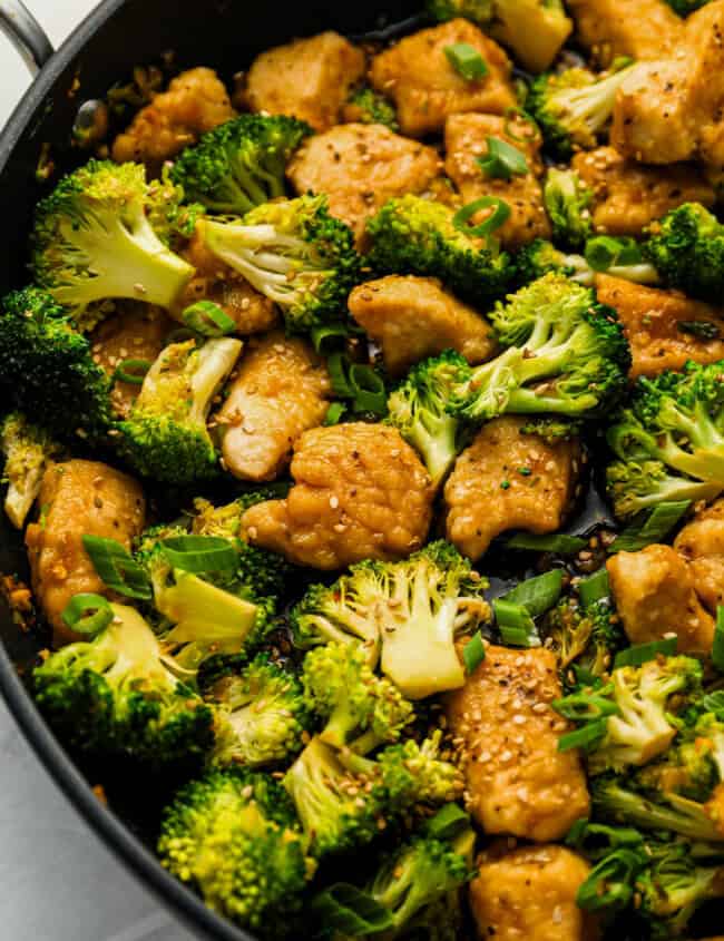 Close up on a stir fry with chicken and broccoli.