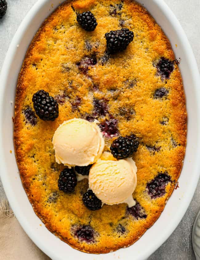 Blackberry cobbler topped with scoops of ice cream.