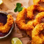 popcorn shrimp on a cutting board with cocktail sauce.