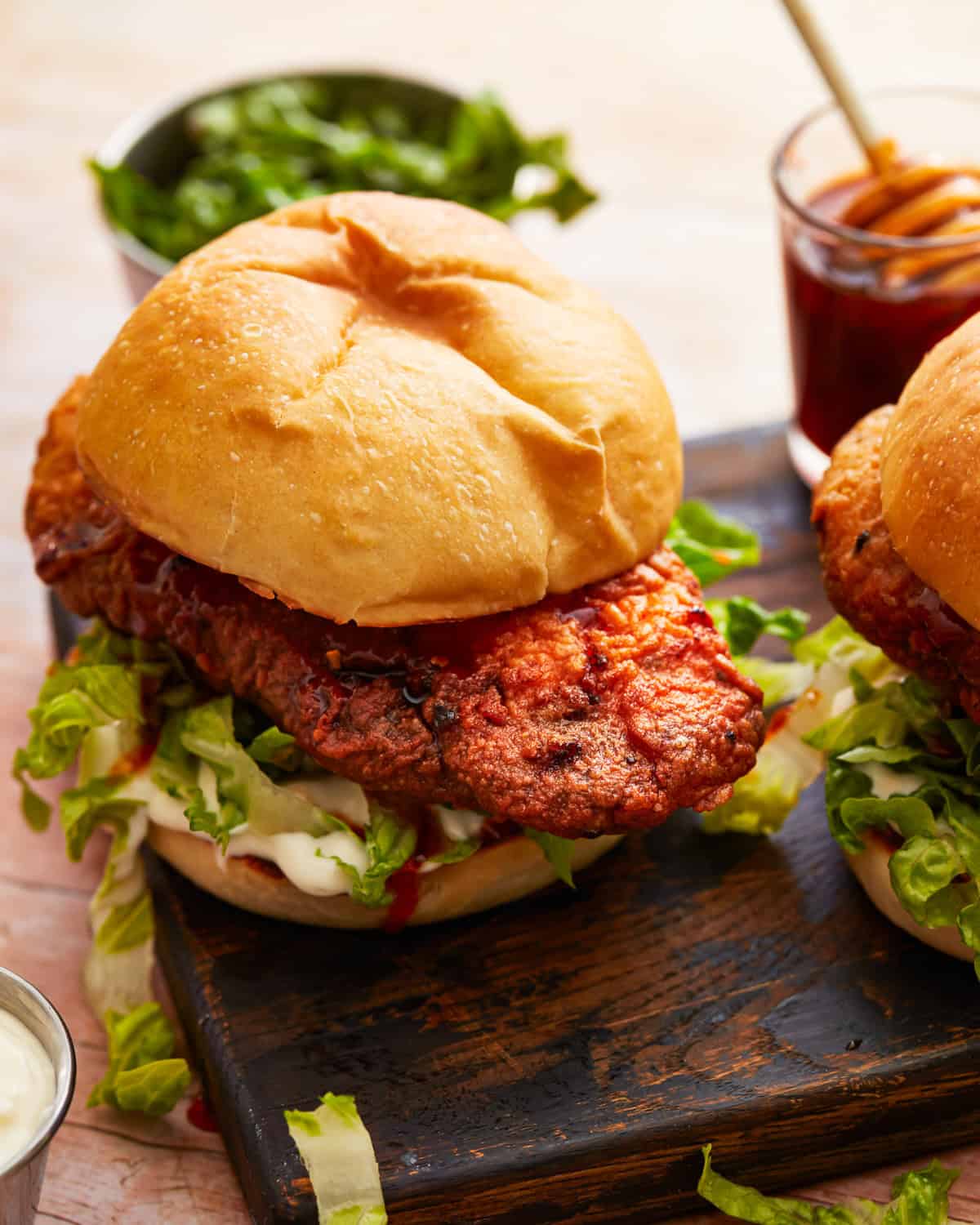 hot honey chicken sandwiches on a black wooden plate.