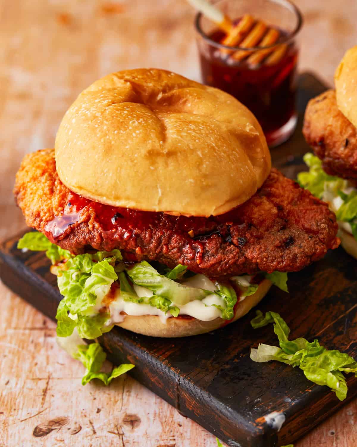 a hot honey chicken sandwich on a black plate.