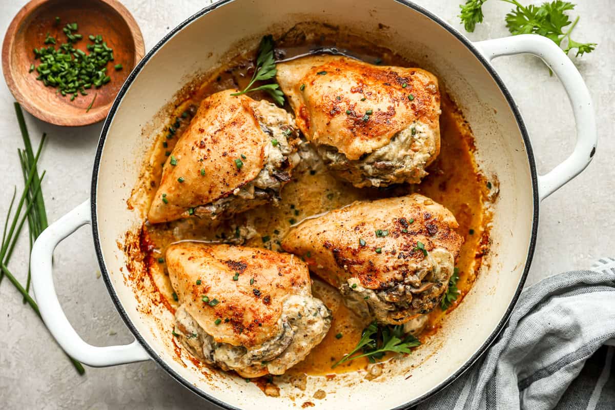 cooked mushroom stuffed chicken breasts in a pan.