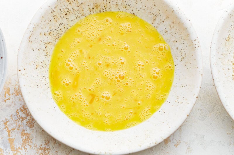 raw scrambled egg in a white bowl.