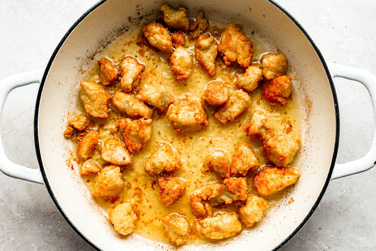 frying chicken pieces in a pot.