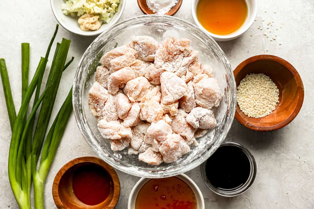 dredged chicken pieces in a glass bowl.