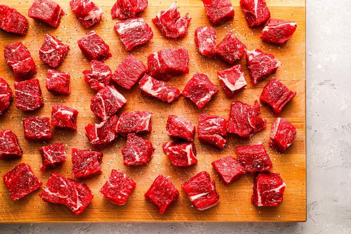 cut raw beef chuck roast pieces on a cutting board.