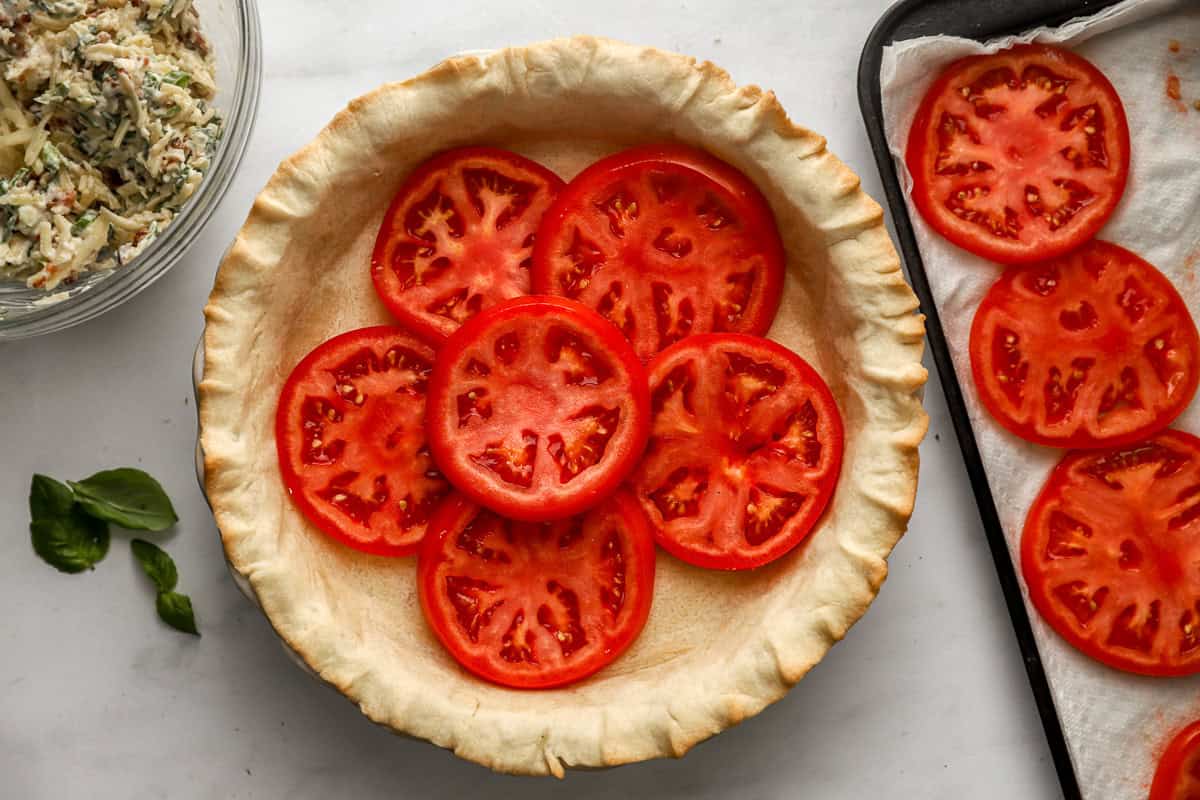 sliced tomatoes layered in a prebaked pie crust.