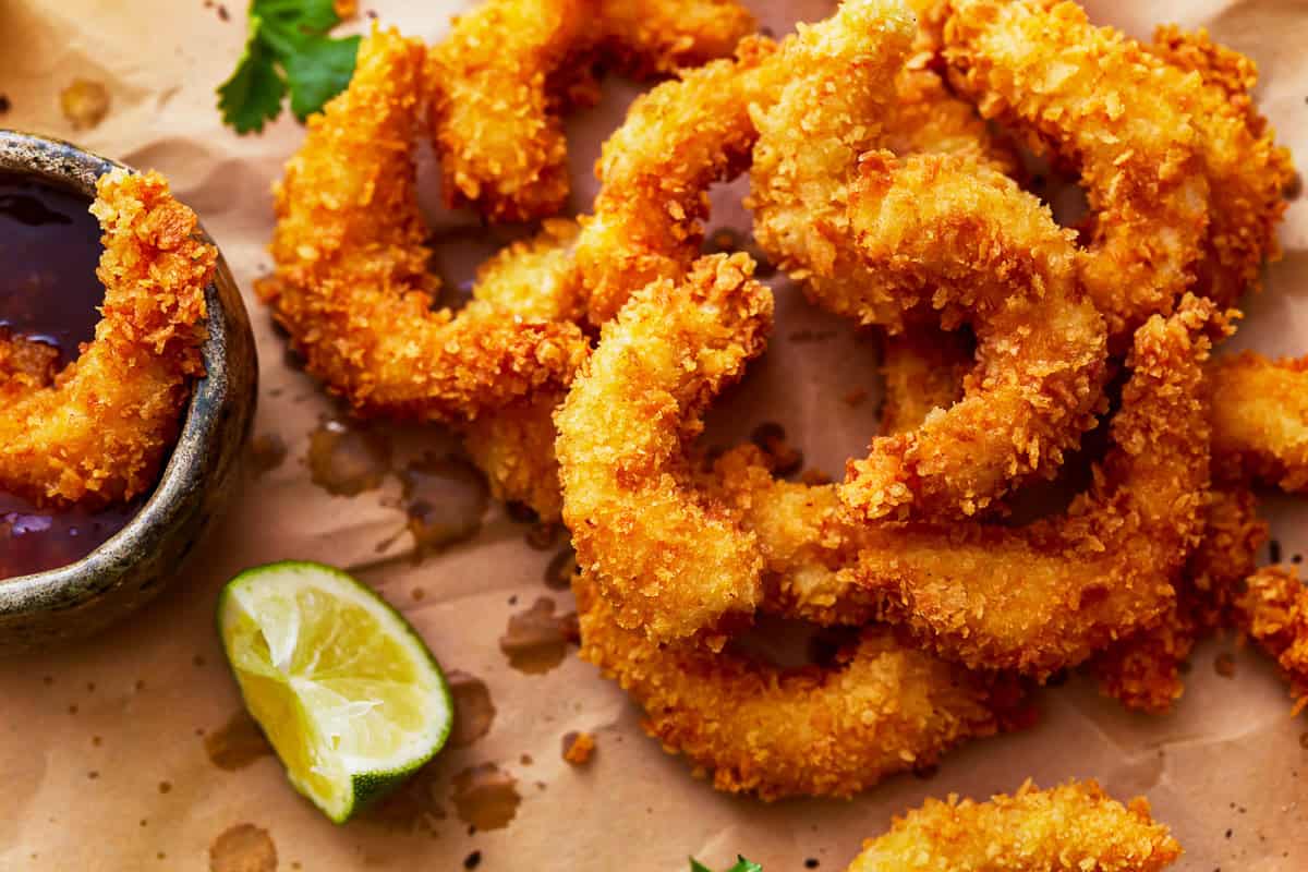 popcorn shrimp on a cutting board with cocktail sauce.