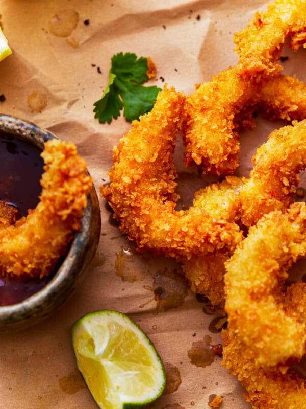 popcorn shrimp on a cutting board with cocktail sauce.