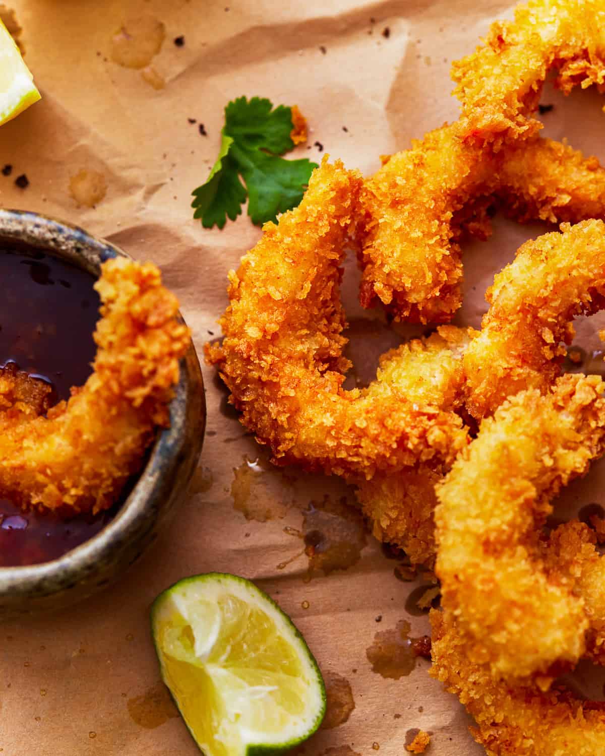 popcorn shrimp on a cutting board with cocktail sauce.