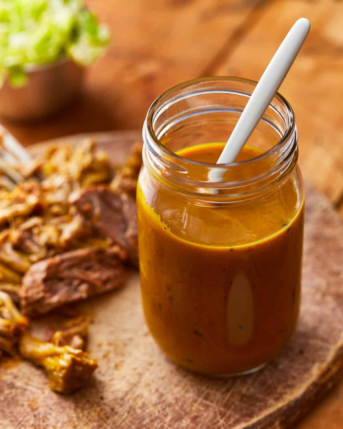 carolina gold sauce in a mason jar with a spoon.