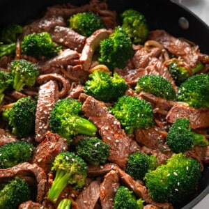 Steak and broccoli stir fry in a skillet.