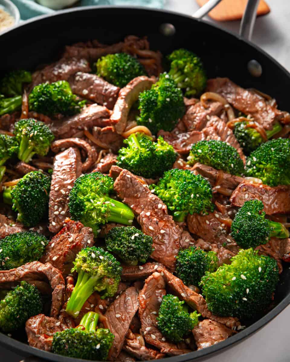 Steak and broccoli stir fry in a skillet.