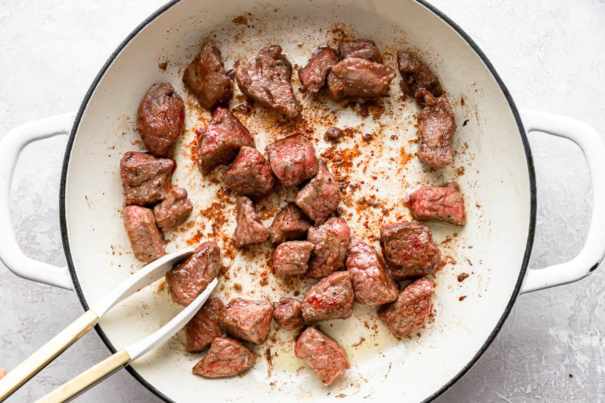 Cubes of beef browning in a pot.