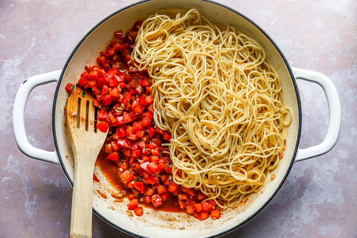 Tomatoes and angel hair pasta in a pot.