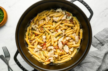 Pasta with chicken, bacon, and ranch seasoning in a dutch oven.