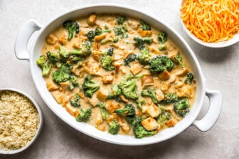 broccoli florets, cubes of chicken, and a creamy sauce in a casserole dish.