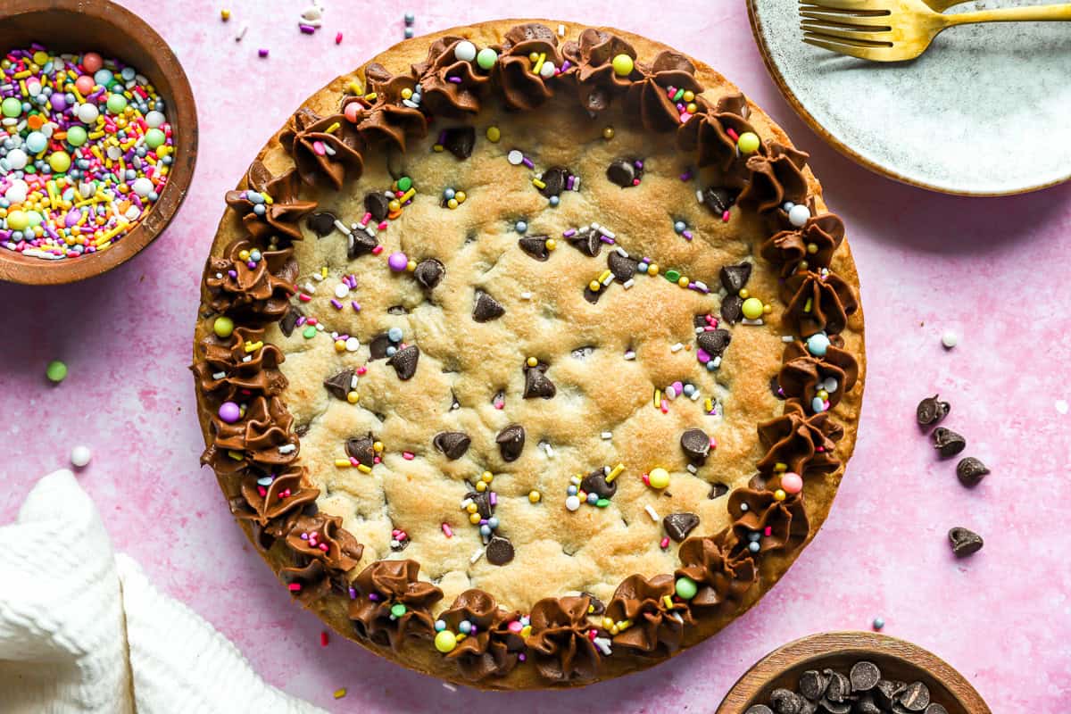 Cookie cake with chocolate chips, decorated with sprinkles and chocolate frosting.