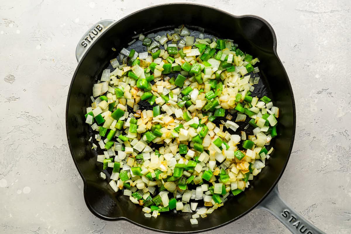 sauteed onions and peppers in a frying pan.