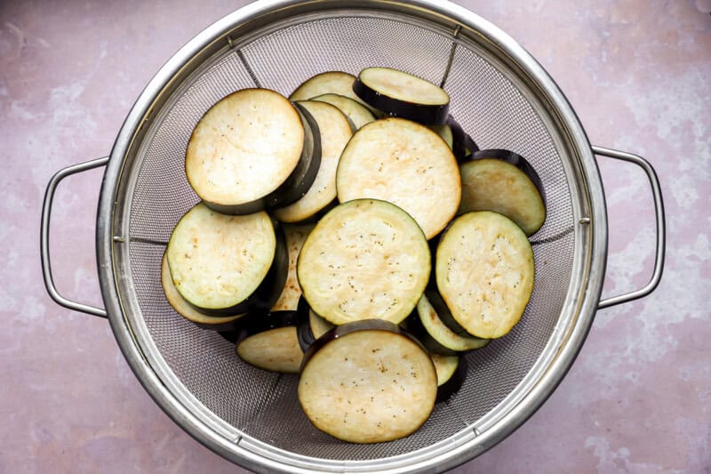 slices of eggplant in a colander.