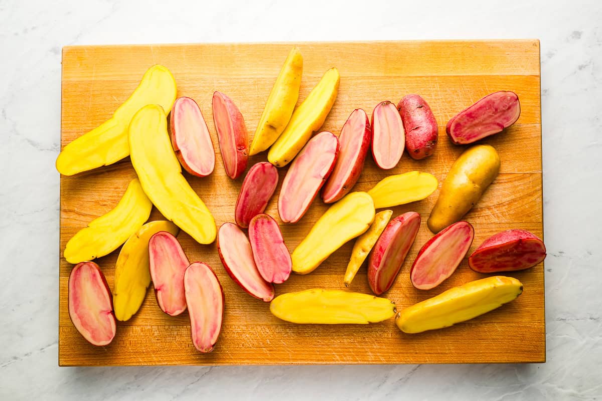 halved fingerling potatoes on a cutting board.