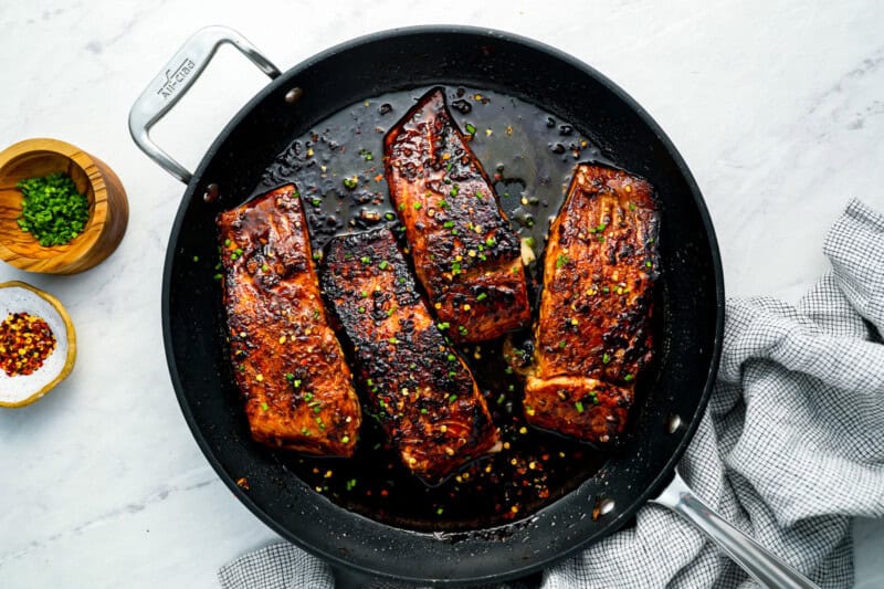 firecracker salmon fillets cooking in a frying pan.