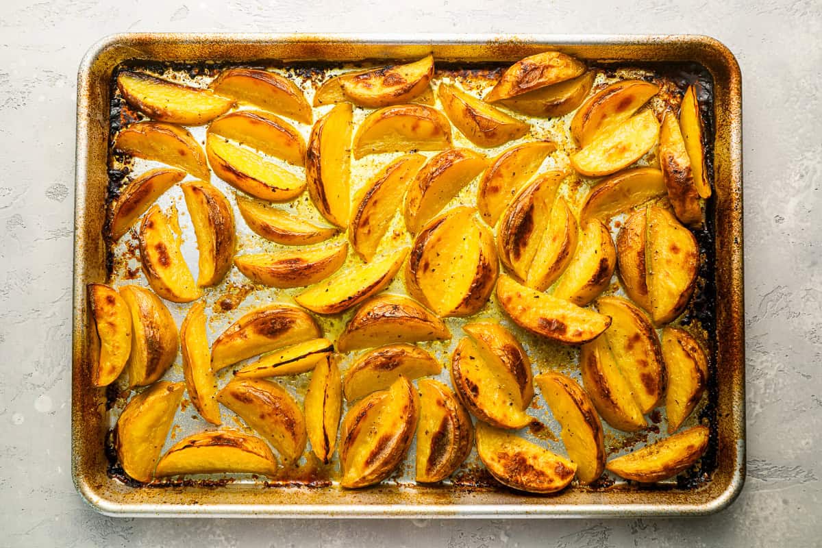 greek potato wedges on a baking sheet.