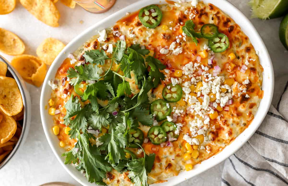 baked mexican street corn dip in an oval baking dish.