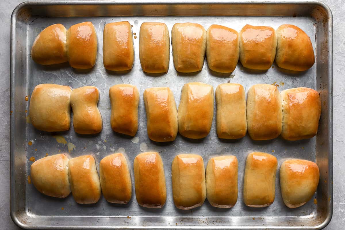 24 texas roadhouse rolls on a baking sheet.