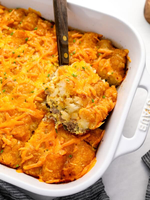 a serving of tater tot breakfast casserole on a spatula resting on the casserole.