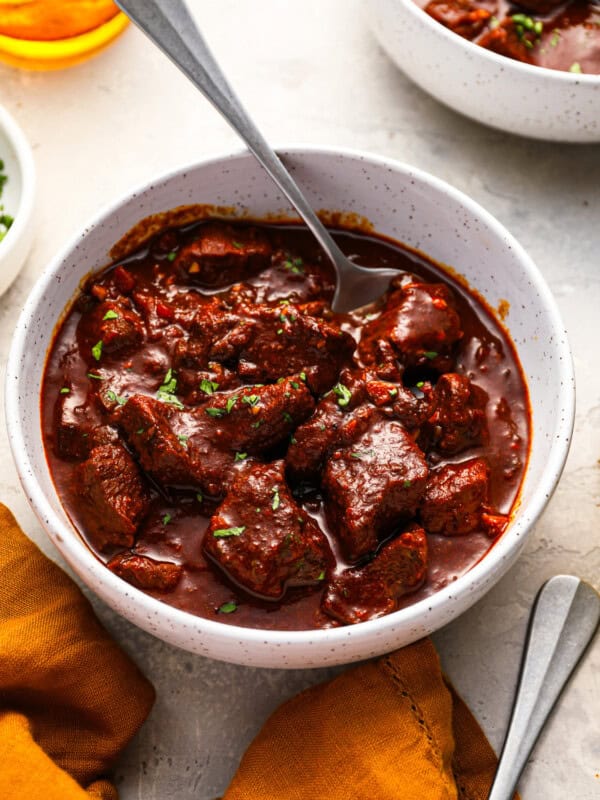 a serving of texas chili in a white bowl with a spoon.