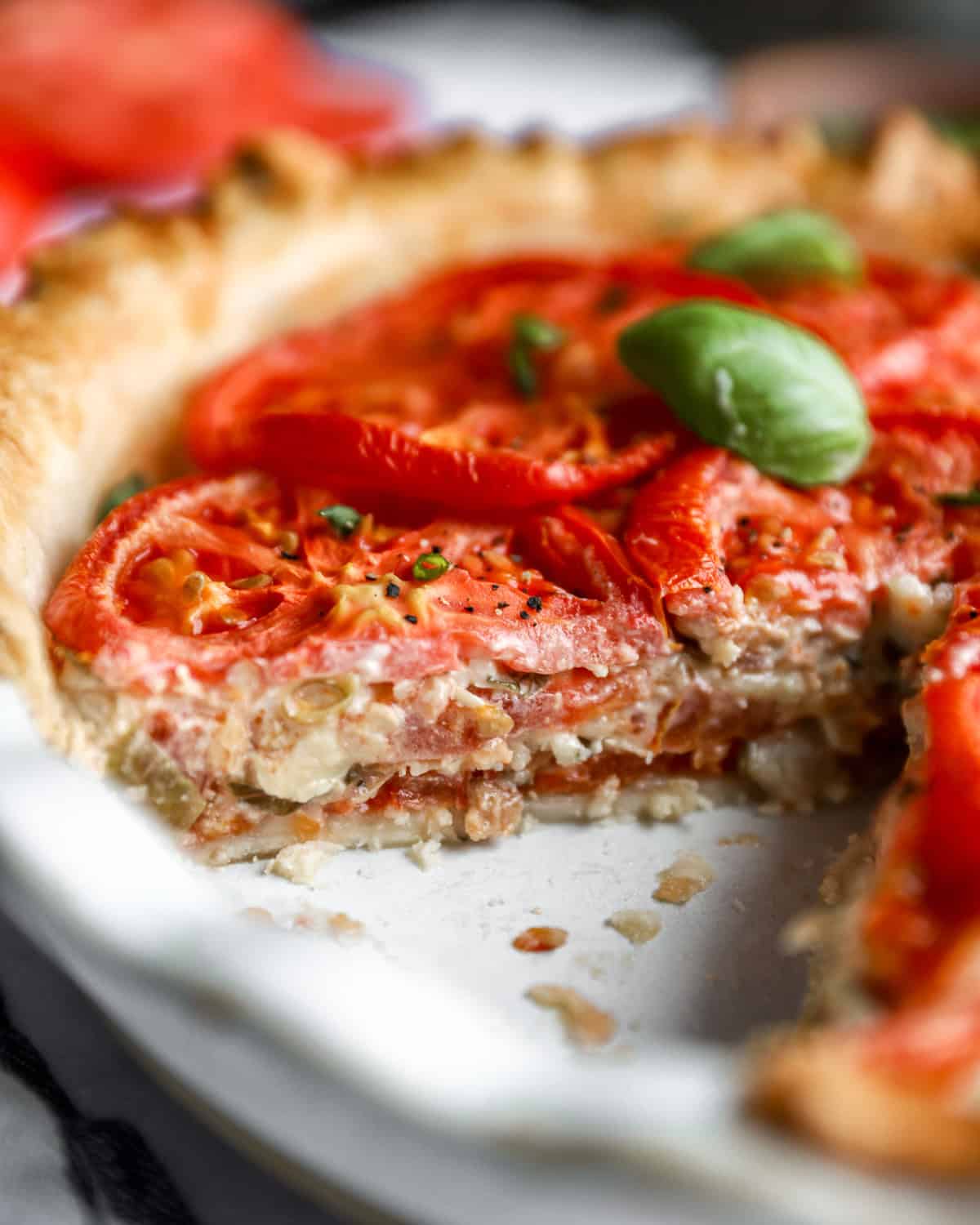 close up view of a cut tomato pie exposing the filling.