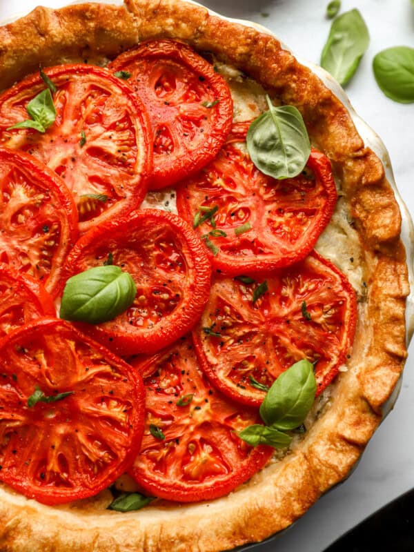 partial overhead view of a tomato pie topped with basil.