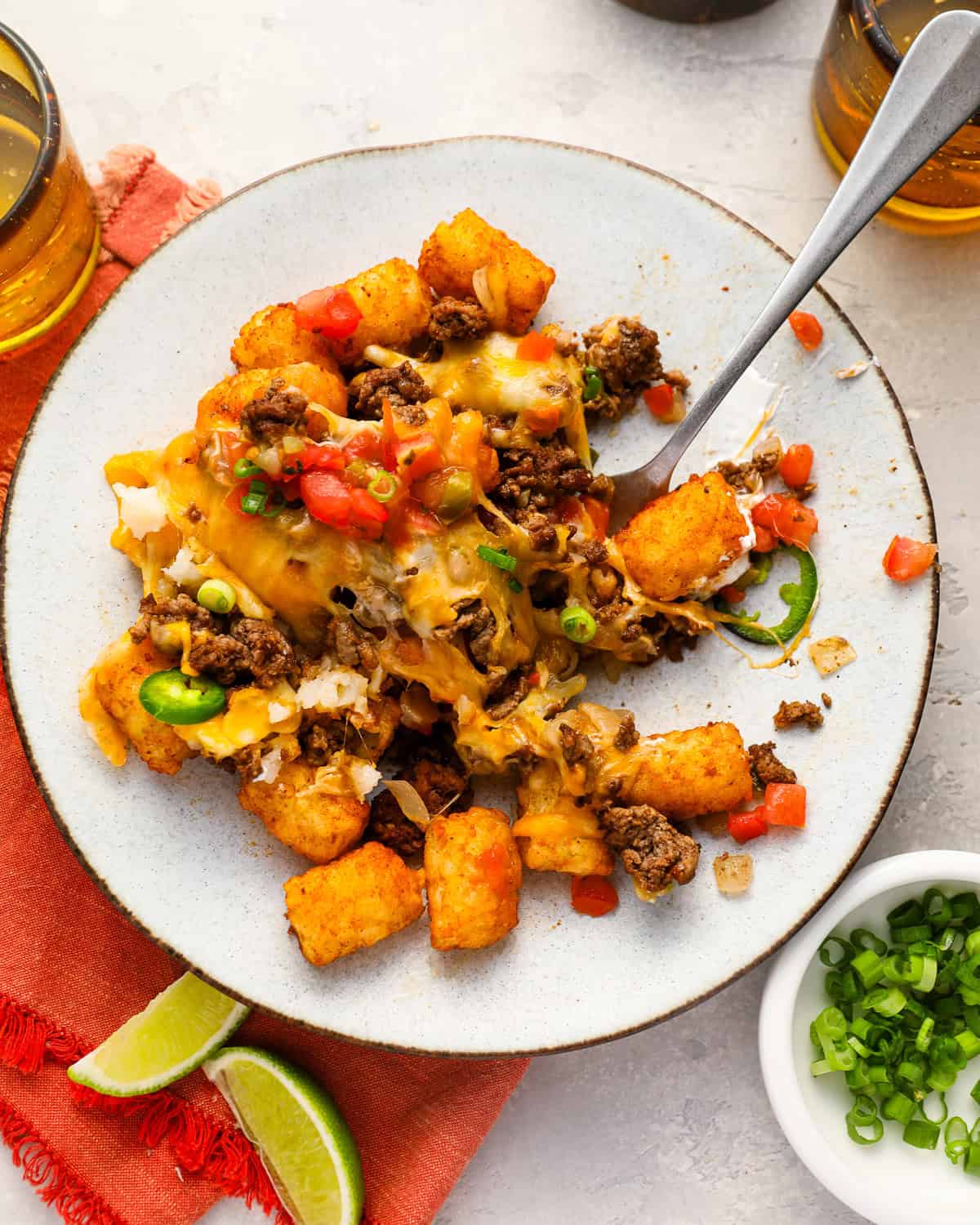 a serving of totchos on a white plate with a fork.