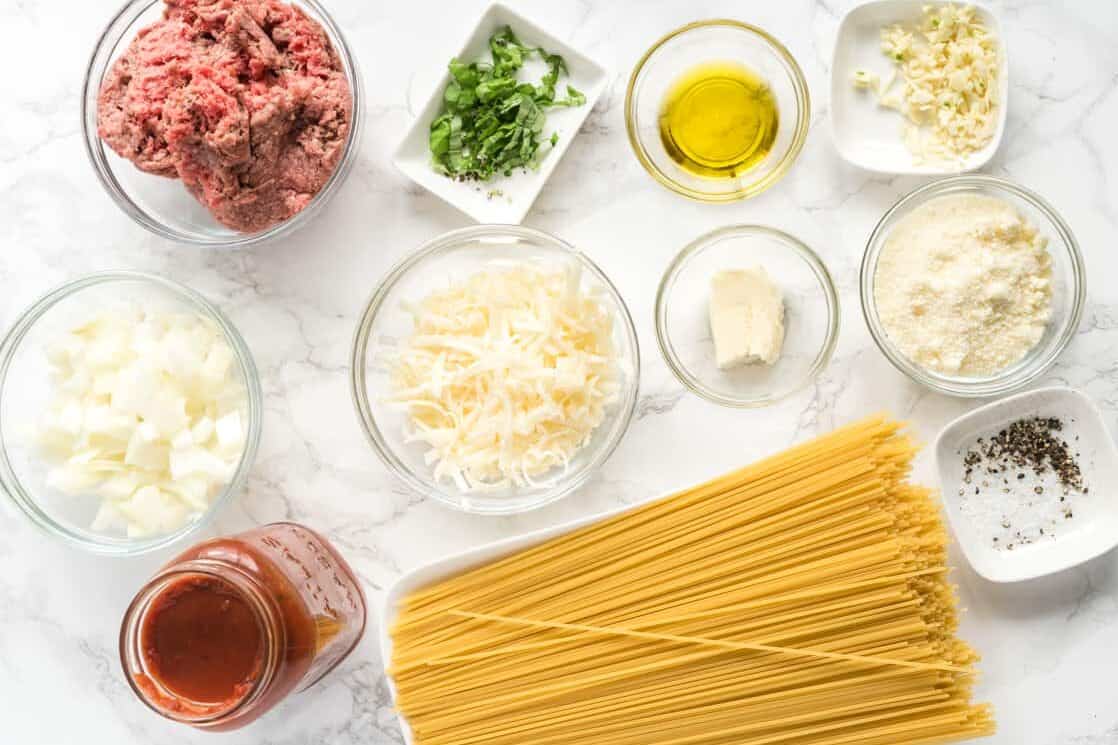 Ingredients for baked spaghetti arranged in glass bowls.