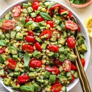 close up overhead view of avocado salad in a white bowl with a serving spoon.