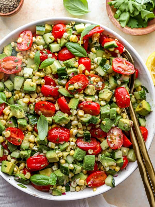 close up overhead view of avocado salad in a white bowl with a serving spoon.