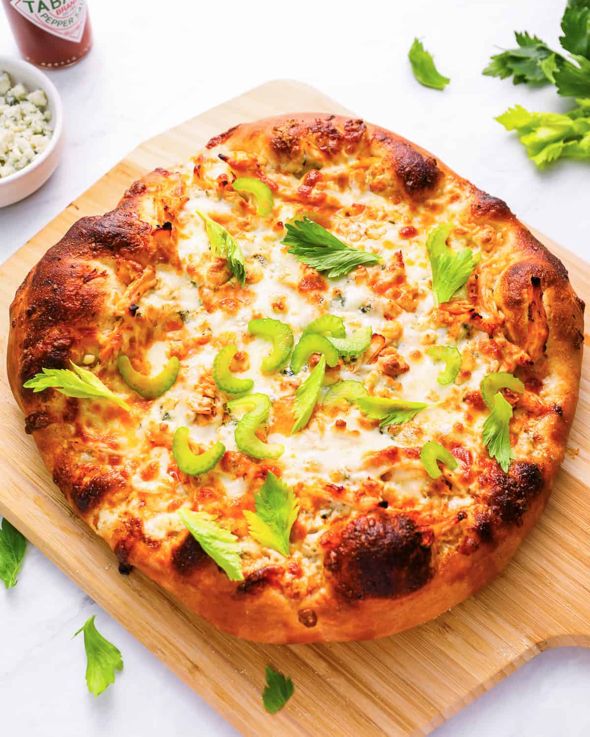 buffalo chicken pizza on a wood pizza peel.