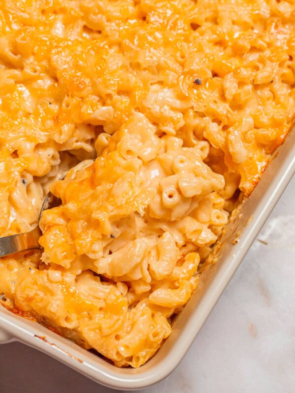 a spoon scooping chick fil a mac and cheese from a casserole dish.
