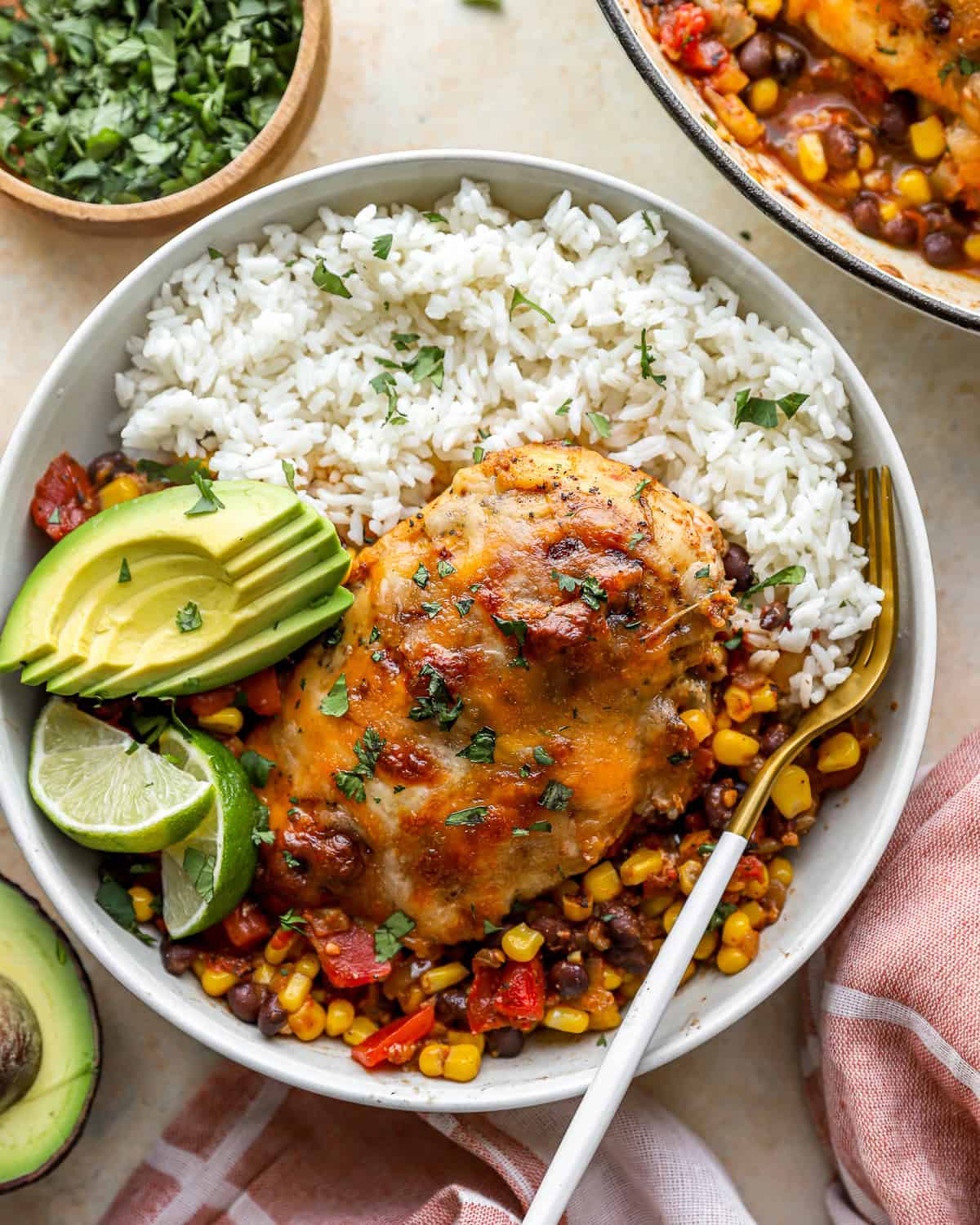 overhead view of a serving of cowboy chicken on a plate with rice and avocado.