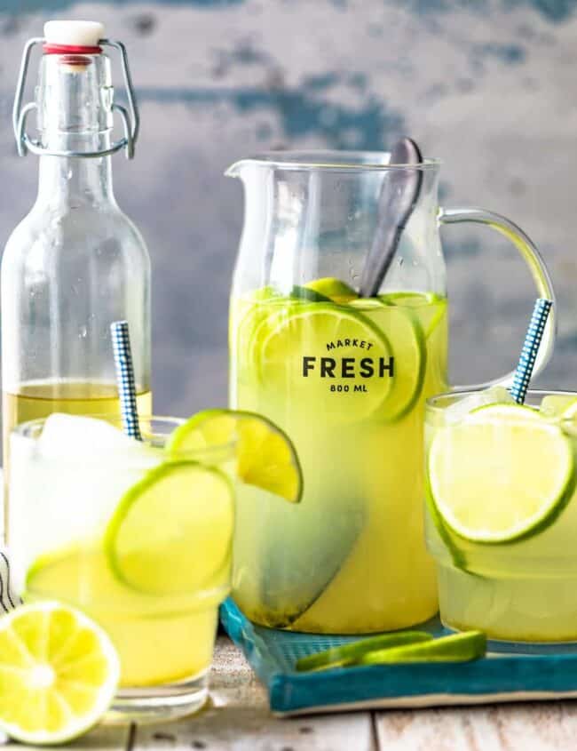 fresh lemonade and limeade in pitchers on a wooden table.